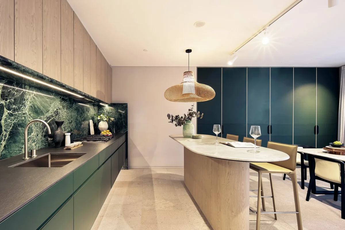 Luxury penthouse kitchen with green marble splashback, timber joinery and a curved island bench